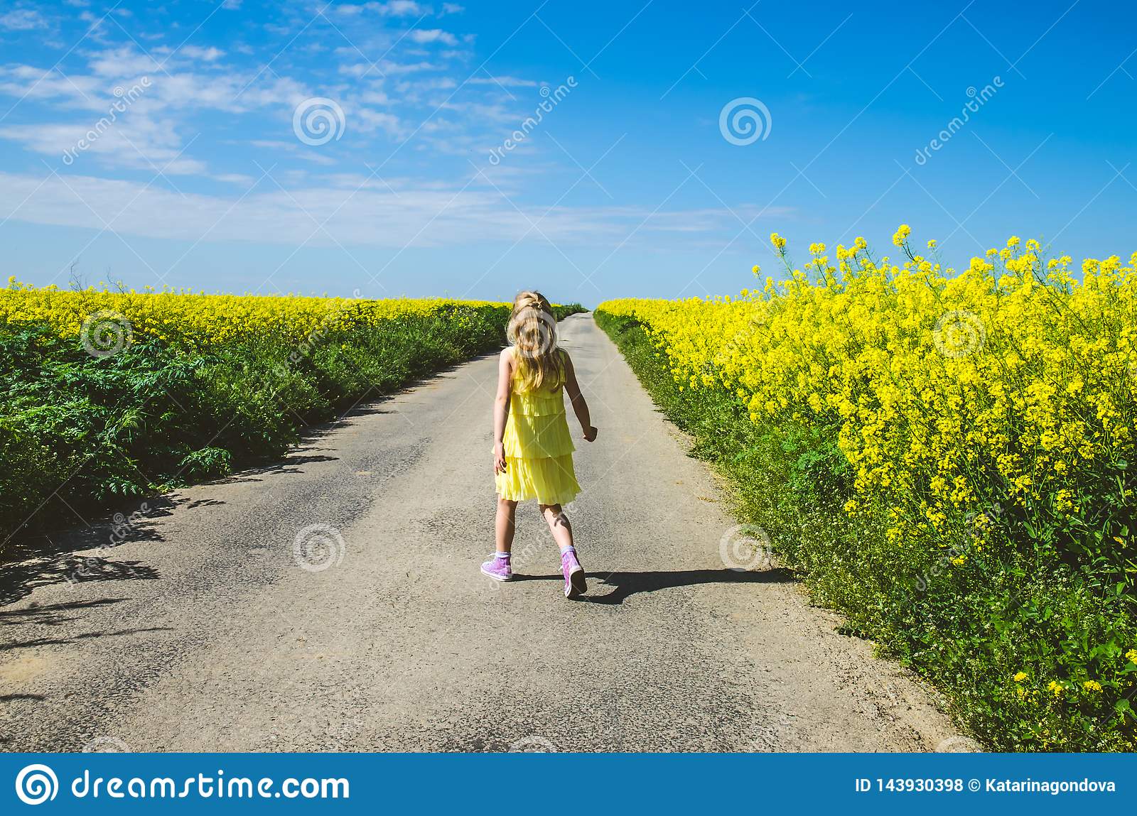 girl walks by fields 